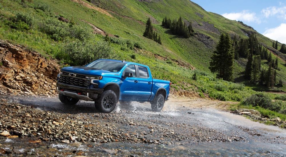 A blue 2024 Chevy Silverado 1500 ZR2 driving to Chevy dealer near you.