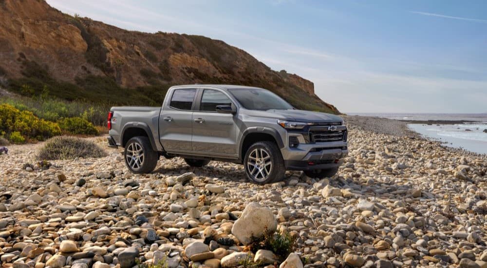 A grey 2024 Chevy Colorado for sale parked on a shore.