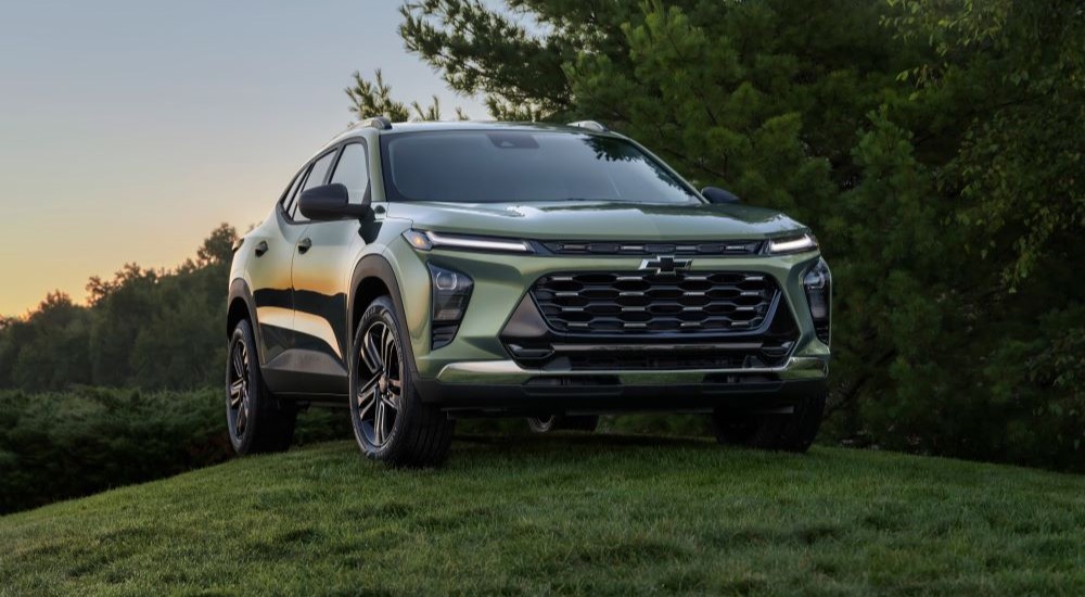 A green 2024 Chevy Trax ACTIV parked on a grassy hill.