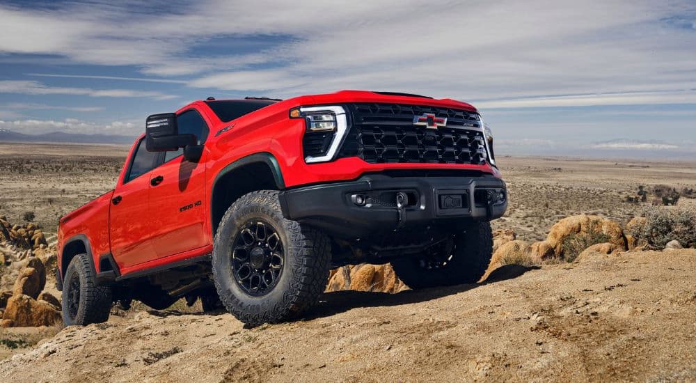 A popular Chevy Silverado for sale, a red 2024 Chevy Silverado 2500HD ZR2 Bison, is shown off-road.