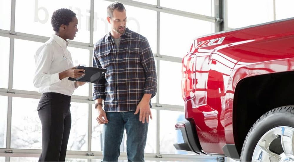 A popular Chevy Silverado for sale, a red 2015 Chevy Silverado 1500 Z71, is shown at a dealership for routine maintenance.