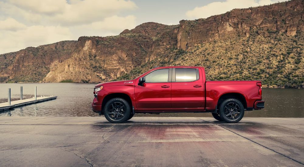 A red 2024 Chevy Silverado 1500 RST Z71 is parked near a lake after leaving a Chevy dealer near Montgomery, LA.