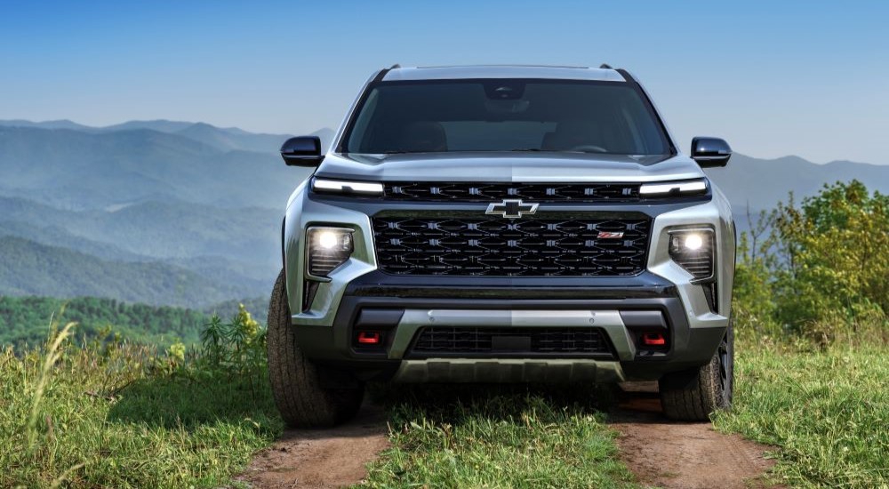 A silver 2024 Chevy Traverse Z71 is shown parked on a grassy hill after leaving a Chevy dealer near you.