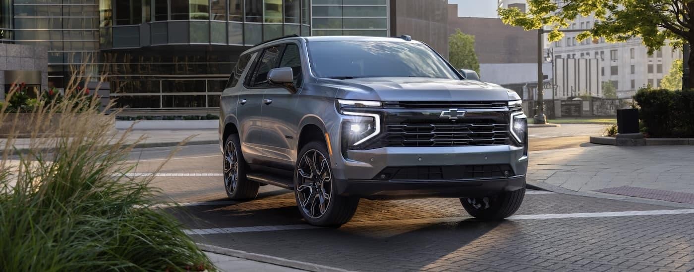 A grey 2025 Chevy Tahoe RST is driving on a city street after leaving a Chevy dealer near Natchitoches.