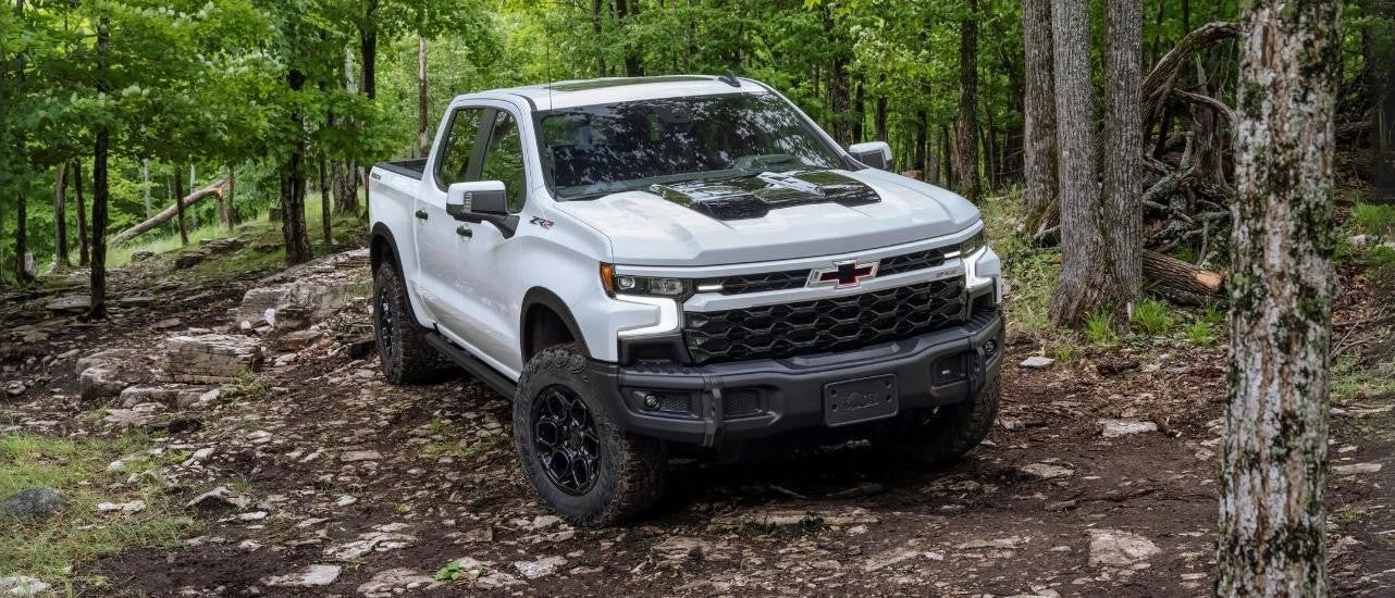 A popular Chevy Silverado for sale, a white 2023 Chevy Silverado 1500 ZR2 Bison, is shown off-road.
