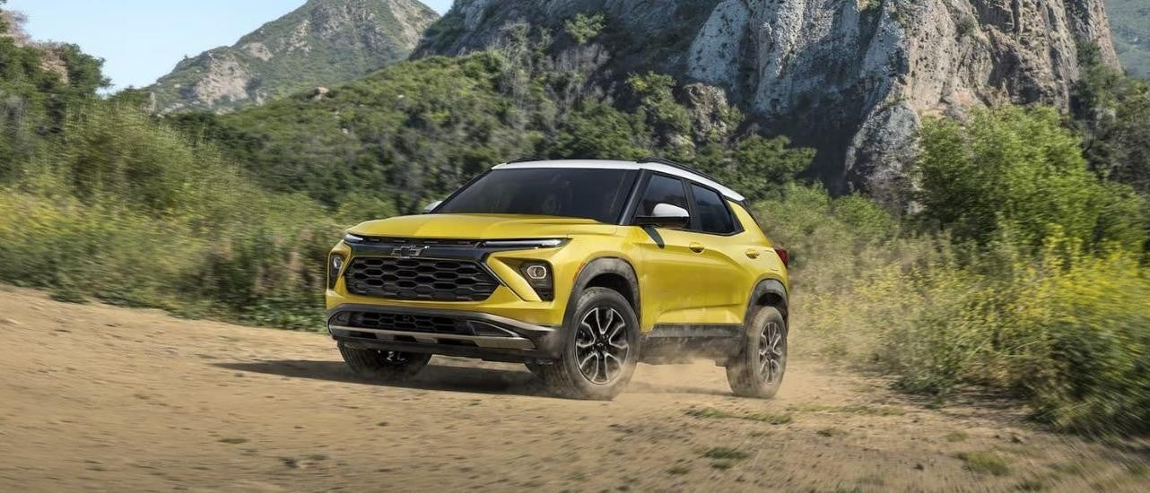  A yellow 2024 Chevy Trailblazer ACTIV is shown kicking up dust.