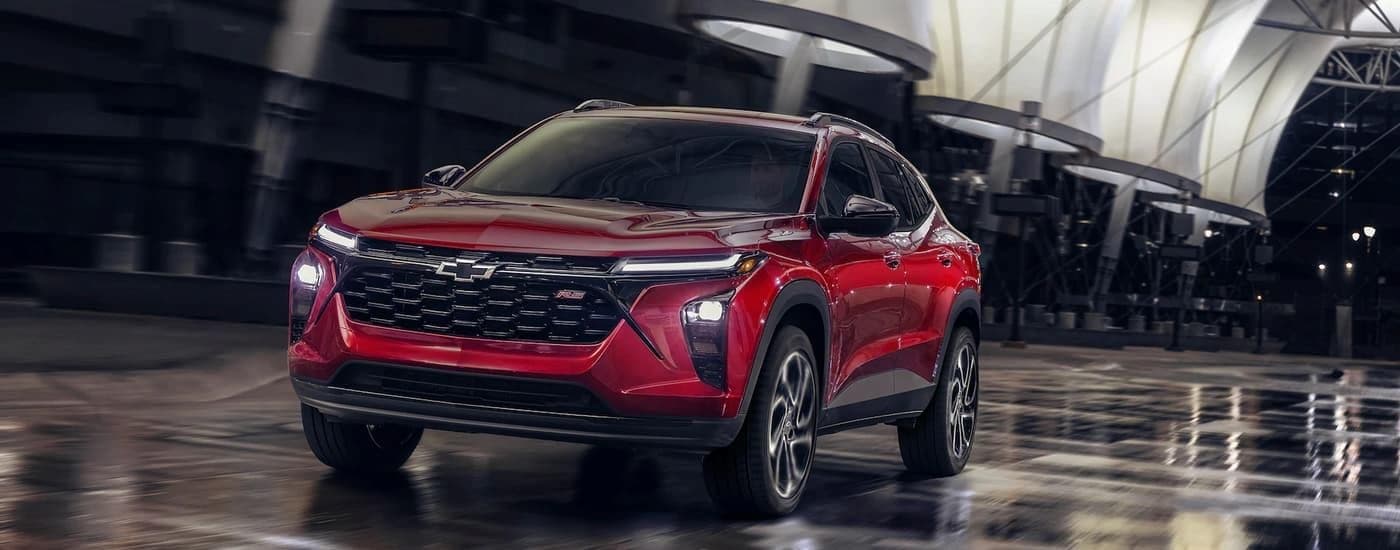 A red 2024 Chevy Trax RS for sale driving on a city street