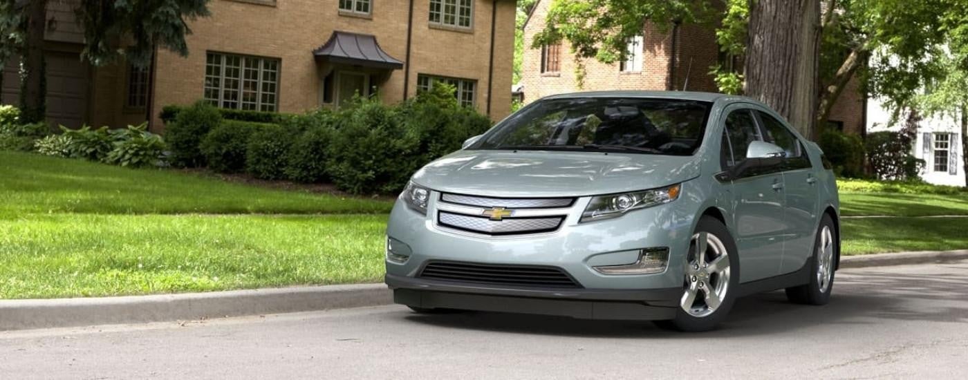 A silver 2013 Chevy Volt is shown on a suburban street after looking at used cars for sale.